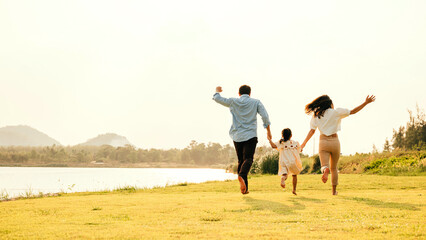 Active lifestyle. a group of family running and having fun in a sunny park, with green grass and blue sky, on a weekend getaway, Happy family day