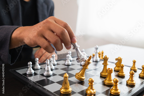 Young businessman planning winning chess move in game of chess representing successful and victorious business path. chess concept representing strategic business strategy to achieve victory.