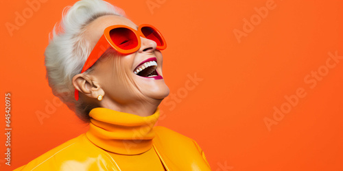 a beautiful old woman laughing on a plain orange background, fashion