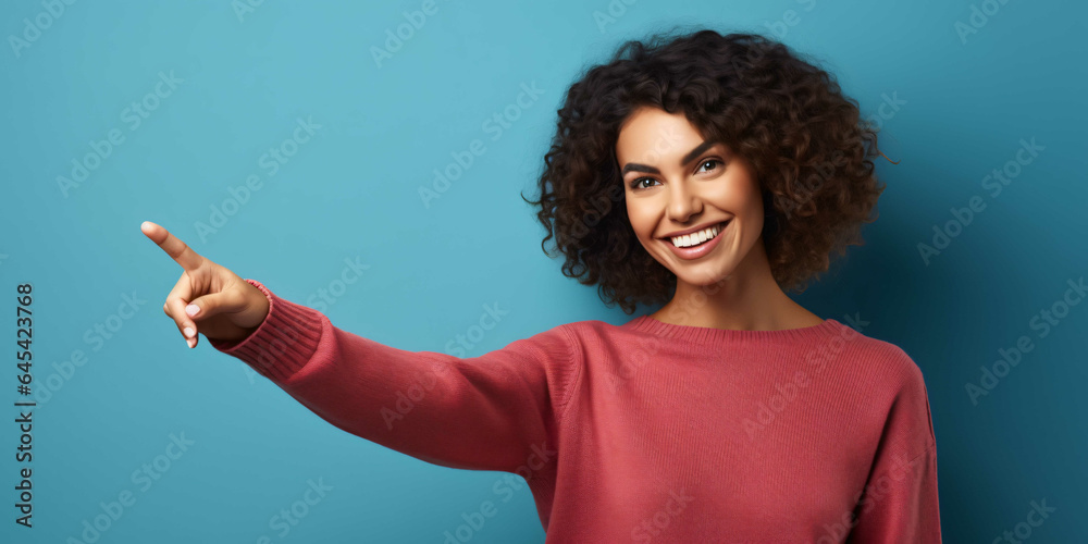 a young woman pointing on a plain blue background, fashio a young woman pointing on a plain blue background, fashio