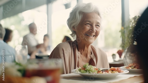 An elderly woman in a retirement home happily eats lunch.