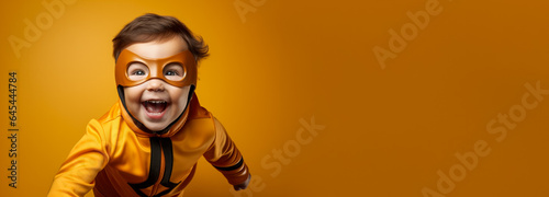 Child in the adventurous costume of a superhero isolated on a vivid background with a place for text 