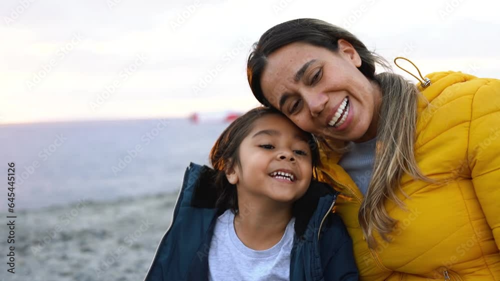 Latin mother having fun with little daughter outdoor during winter time - Family love concept Latin mother having fun with little daughter outdoor during winter time - Family love concept