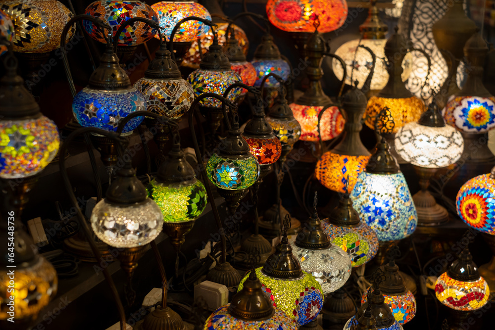 Many traditional colorful glass lanterns for sale at a local craft market. Selective focus, blurred background. Deira market in Dubai, UAE.