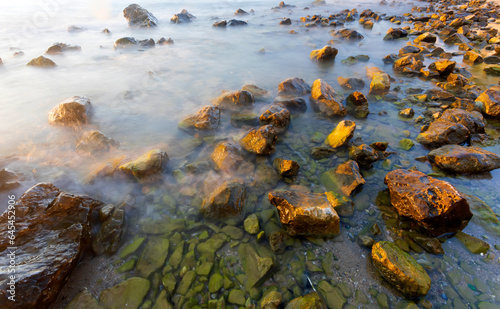 Sunset and sea rocks. Photo taken with the long exposure technique. © serkanmutan