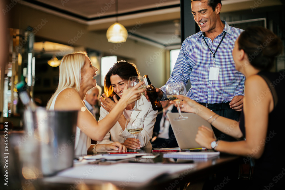 Diverse group of colleagues having drinks after work in a bar Diverse group of colleagues having drinks after work in a bar