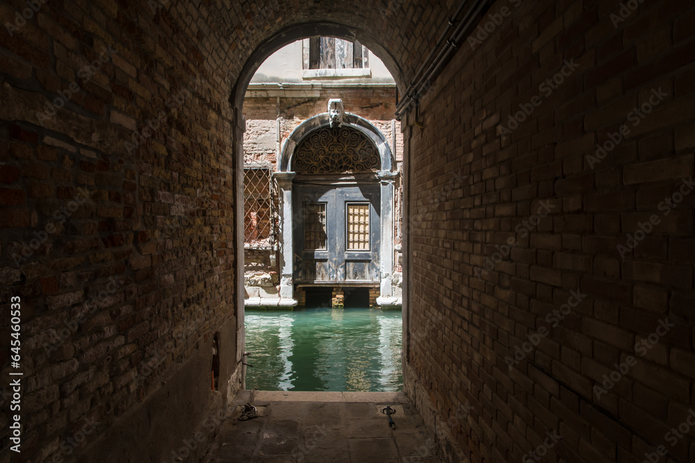 Un sotoportego si affaccia su un canale e un palazzo storico a Venezia