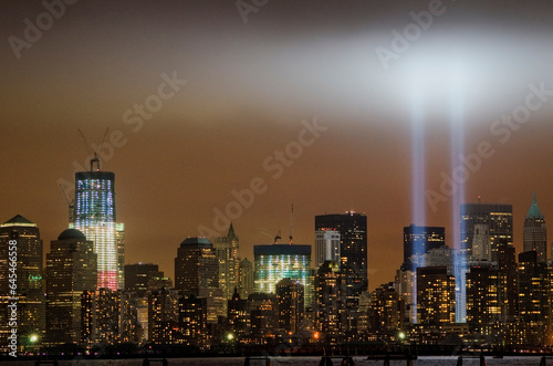 9/11 lights over the skyline of Manhattan and 1 World Trade Center illuminated in red, white, and blue