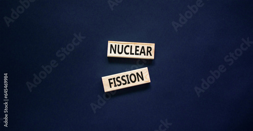 Nuclear fission symbol. Concept words Nuclear fission on beautiful wooden blocks. Beautiful black table black background. Business science nuclear fission concept. Copy space.