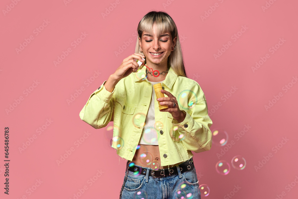 Young happy woman blowing soap bubbles in studio Young happy woman blowing soap bubbles in studio