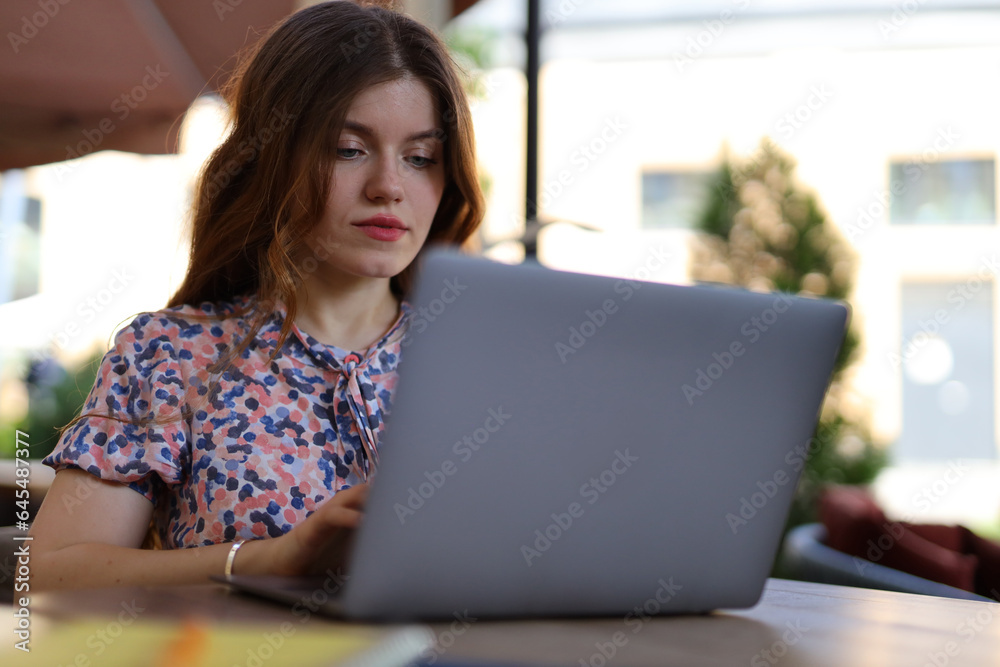 A young, smart, and beautiful woman working on her laptop in a cafe, combining modern technology with a coffee shop ambiance. A young, smart, and beautiful woman working on her laptop in a cafe, combining modern technology with a coffee shop ambiance.