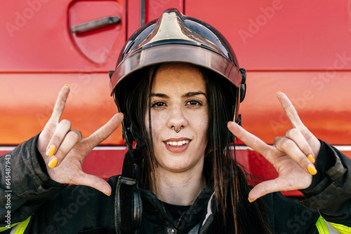 Woman with helmet showing horn sign photo