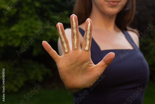 Obraz na płótnie A woman applying the correct amount of sunscreen for face and neck (three finger lengths). w salonie
