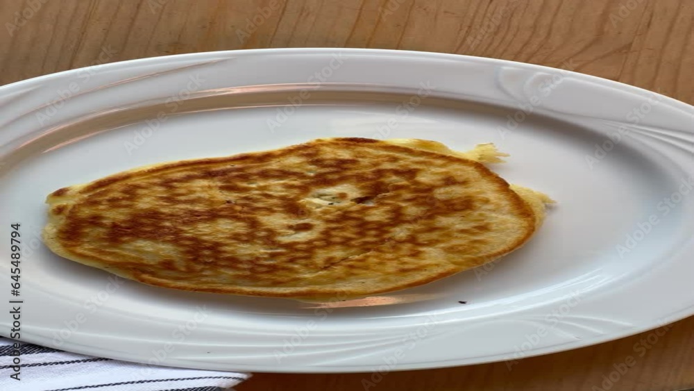 A woman butters three homemade pancakes, and adds syrup A woman butters three homemade pancakes, and adds syrup