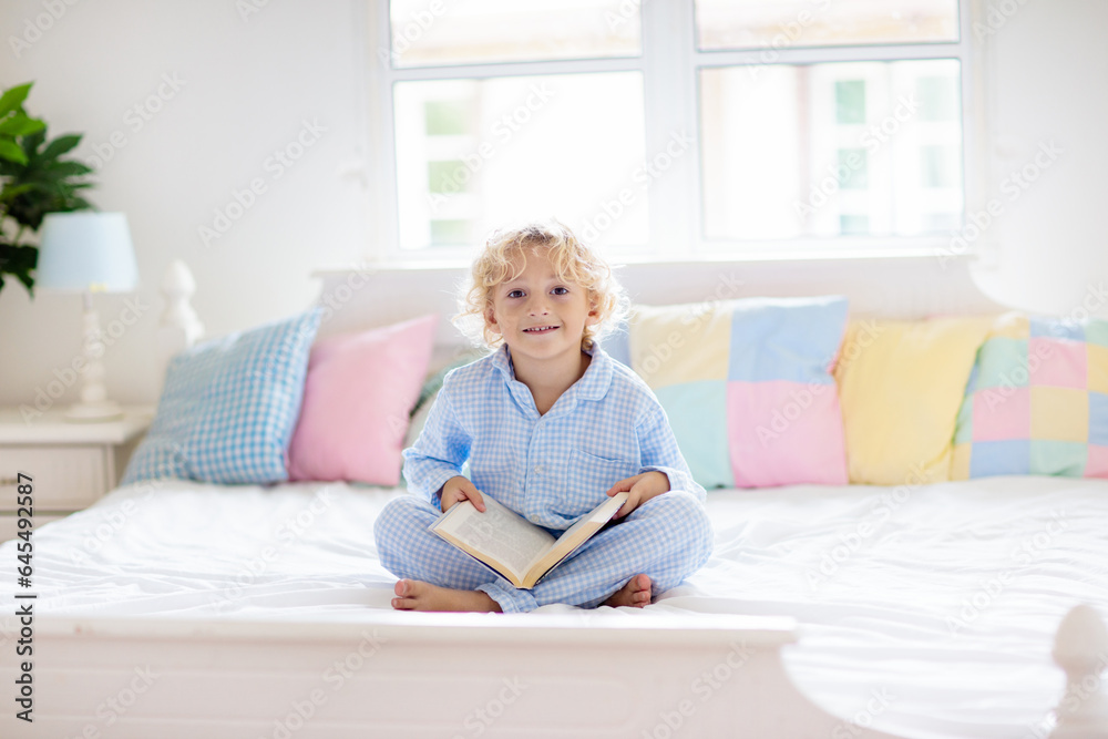 Child reading book in bed. Kids read in bedroom. Child reading book in bed. Kids read in bedroom.
