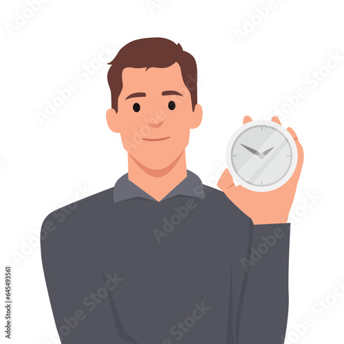 Smiling man points finger at alarm clock to remind of beginning or end of lunch break. Concept time management and control over optimal use of working period.