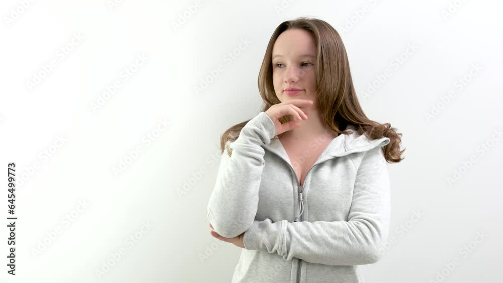 A young woman standing in front of a white wall and making a surprise gesture. High quality 4k footage