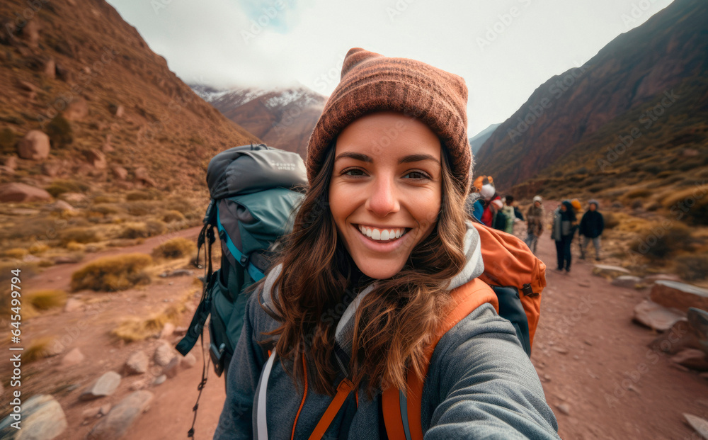 Enthusiastic Young Native Woman, Backpack-Clad, Captures a Selfie While Trekking in Morocco, Near the Majestic Jebel Toubkal, the Summit Peak of the Atlas Mountains

