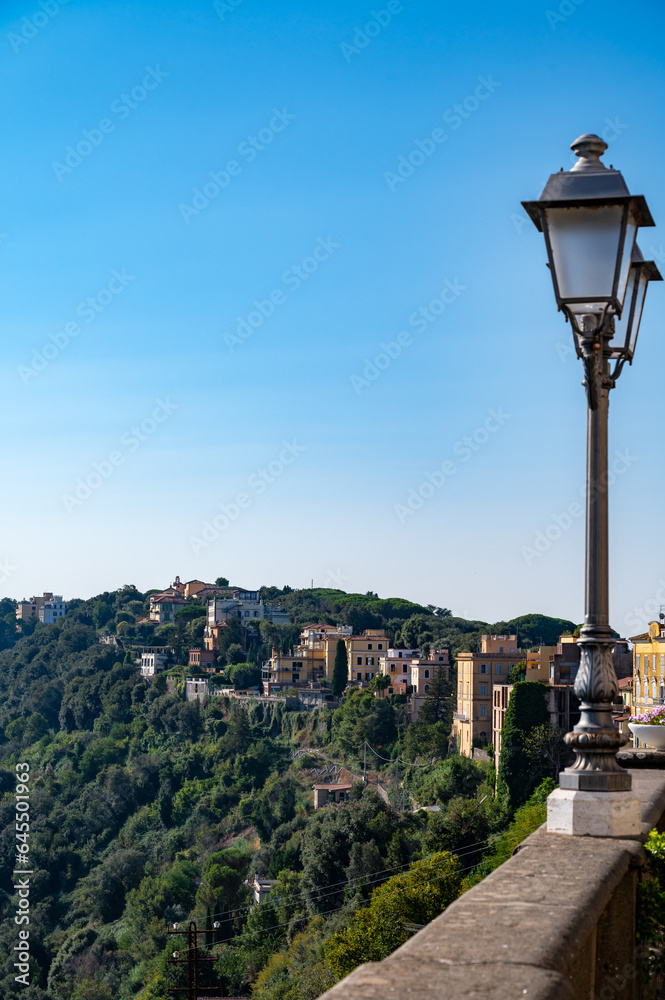 Walking in Castel Gandolfo, summer residence of pope, view on green Alban hills overlooking volcanic crater lake Albano, Castelli Romani, Italy in summer
