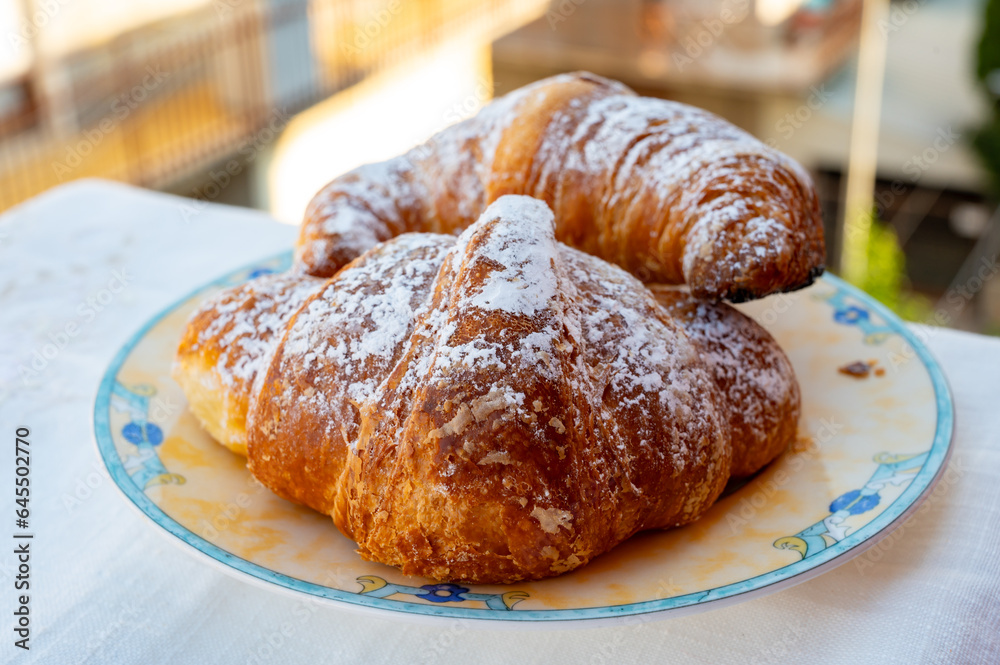 Italian sweet breakfast, fresh baked croissant buttery pastry with sugar powder Italian sweet breakfast, fresh baked croissant buttery pastry with sugar powder