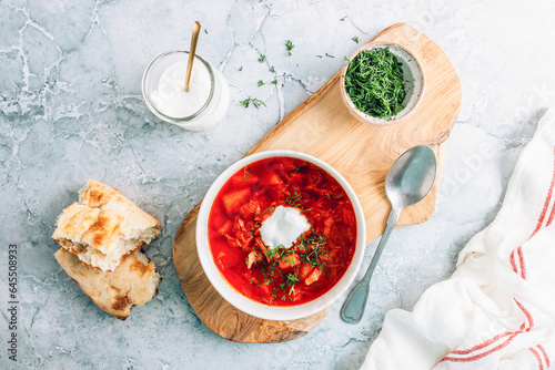 Traditional Russian and Ukrainian Borscht Meal with Bread, Sour Cream, and Fresh Herbs