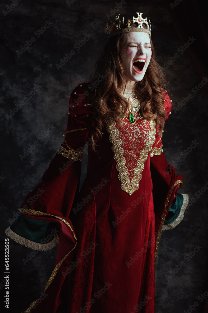 mad medieval queen in red dress with white makeup and crown