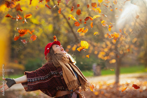 happy trendy 40 years old woman in red hat rejoicing