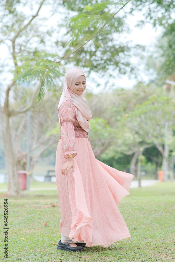 Portrait of beautiful young Muslim girl wearing Hijab and dress in outdoor scenes. Stylish Muslim female hijab fashion lifestyle portraiture concept.