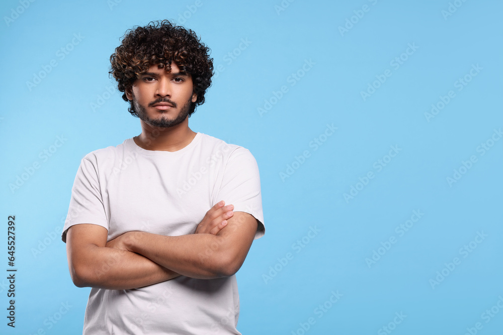 Handsome young man on light blue background, space for text Handsome young man on light blue background, space for text