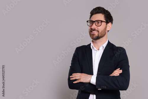 Happy real estate agent in glasses on grey background. Space for text
