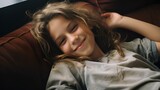 Smiling little young girl enjoying day off lying on the couch. healthy life style, good vibes and new home concept. generative AI