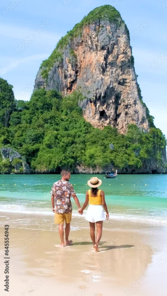 Railay Beach Krabi Thailand, the tropical beach of Railay Krabi, a couple of men and women on the beach walking in the morning on a sunny day, Railay Beach Krabi Thailand, the tropical beach of Railay Krabi, a couple of men and women on the beach walking in the morning on a sunny day,