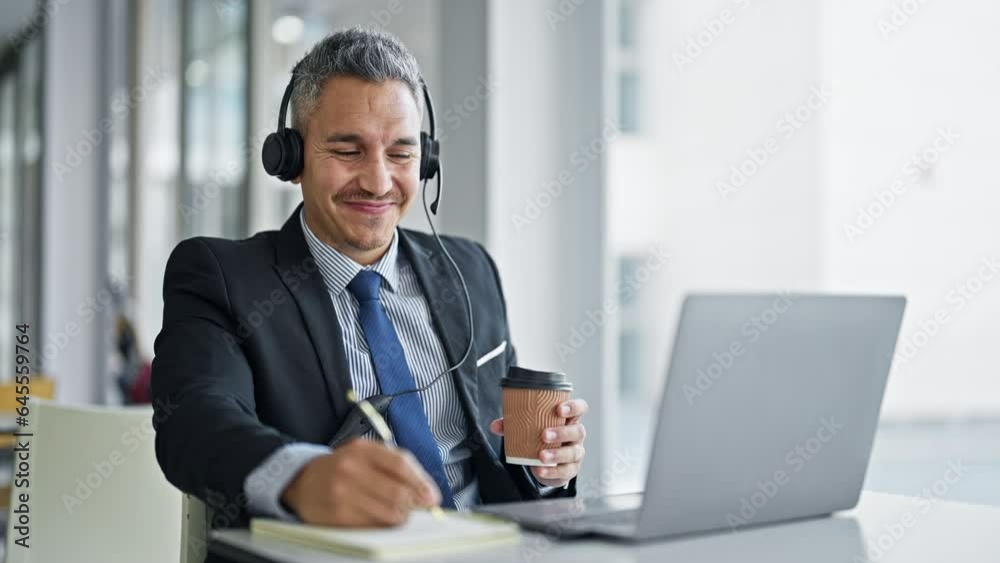 Young hispanic man business worker having video call taking notes at office Young hispanic man business worker having video call taking notes at office
