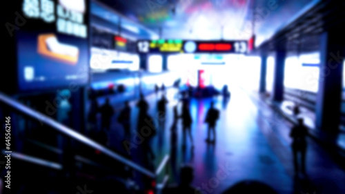 Blurred background of busy subway station with people around train station during rush hour.