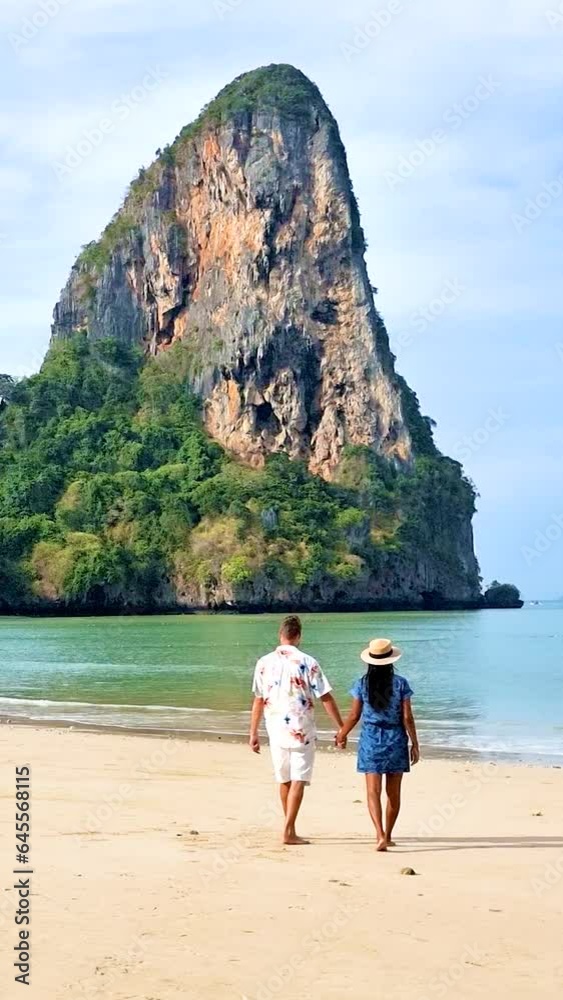 Railay Beach Krabi Thailand, the tropical beach of Railay Krabi, a couple of men and women on the beach walking in the morning on a sunny day, Railay Beach Krabi Thailand, the tropical beach of Railay Krabi, a couple of men and women on the beach walking in the morning on a sunny day,