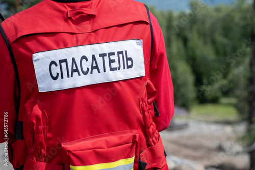 Rescuer in Russia in a uniform with the inscription on the back Rescuer. A man in a red jacket is ready to help in trouble and save lives.