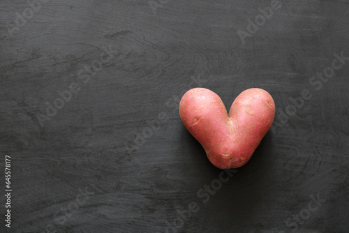 potato in the form of a heart, a root vegetable of a strange shape, top view. photo