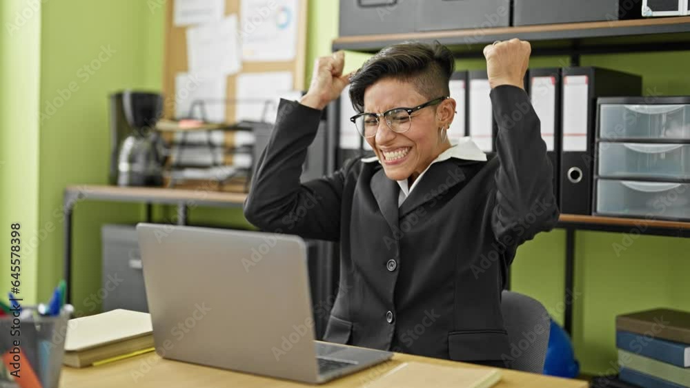 Young beautiful hispanic woman business worker using laptop with winner gesture at office Young beautiful hispanic woman business worker using laptop with winner gesture at office