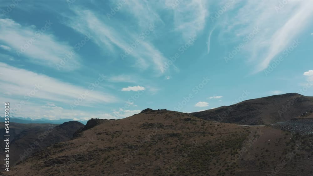 This stock video shows the blue sky and white clouds over the mountains on a sunny summer day. This video will decorate your projects related to nature, weather, mountain landscapes. This stock video shows the blue sky and white clouds over the mountains on a sunny summer day. This video will decorate your projects related to nature, weather, mountain landscapes.