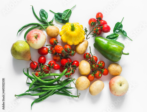 A variety of seasonal vegetables and fruits on a white background - cherry tomatoes  potatoes  string beans  squash  pear  apple