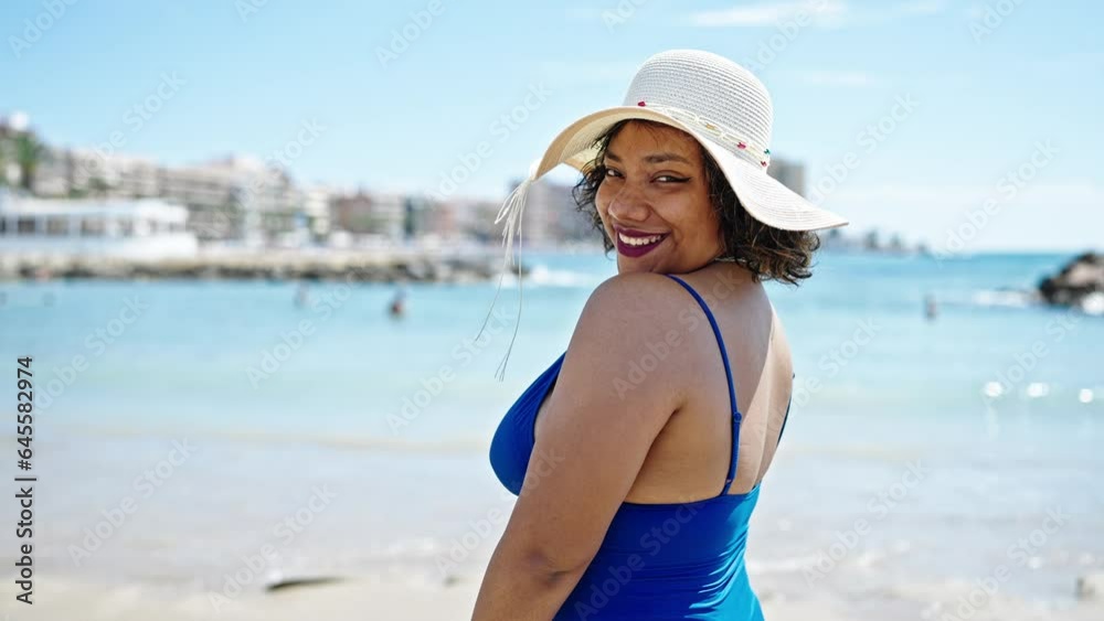 Young beautiful latin woman tourist smiling confident wearing swimsuit and summer hat at beach Young beautiful latin woman tourist smiling confident wearing swimsuit and summer hat at beach