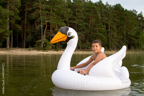 Outdoor recreation with family, child playing with inflatable swan.