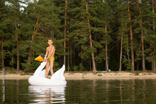 Outdoor recreation with family, child playing with inflatable swan.