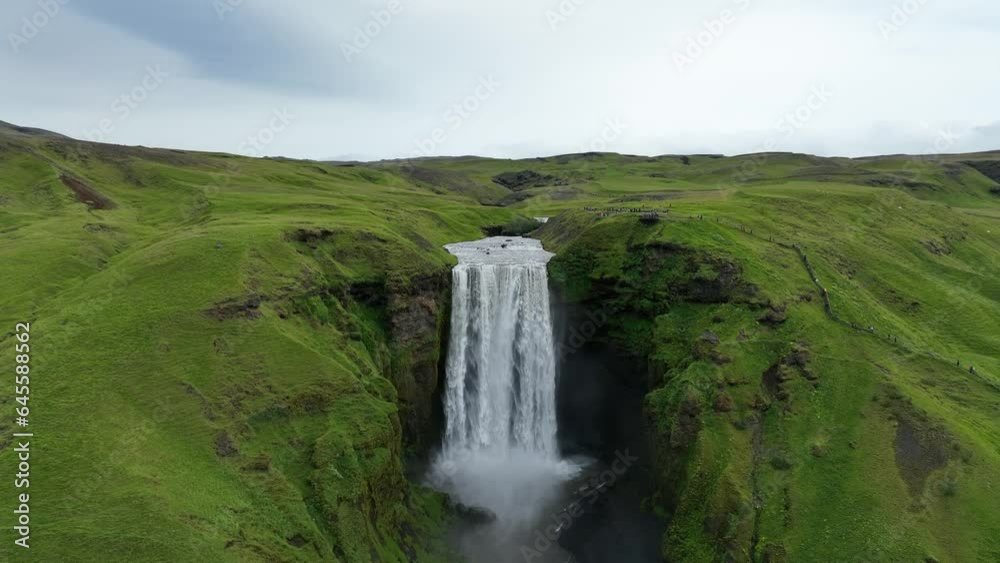 Skogafoss waterfall in the mountains in iceland. Aerial view Skógafoss is one of Iceland's biggest and most beautiful waterfalls with an astounding width of 25 meters and a drop of 60 meters Skogafoss waterfall in the mountains in iceland. Aerial view Skógafoss is one of Iceland's biggest and most beautiful waterfalls with an astounding width of 25 meters and a drop of 60 meters