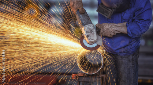 Plakat Industrial worker cutting metal with many sharp sparks