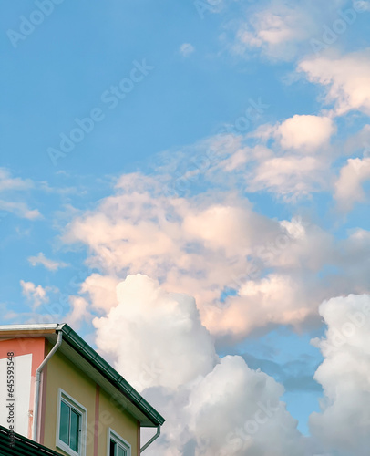 A cloudy sunset sky in a street in Thailand. Looking up views and classic roofs of houses.