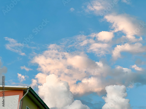 A cloudy sunset sky in a street in Thailand. Looking up views and classic roofs of houses.