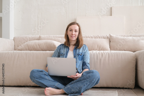 Nice beautiful lady work at the laptop sitting on the sofa at home. technology woman concept for alternative office freelance. Distance home office