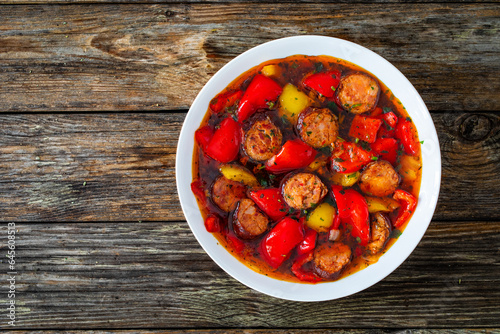 Delicious lecho - vegetables with sausages on wooden table
 photo