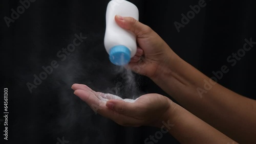 Female hand with talcum powder isolated on black background.